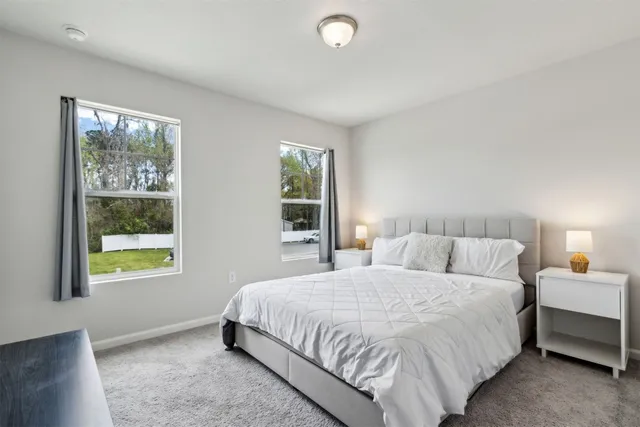 a bedroom with a bed lamp and window