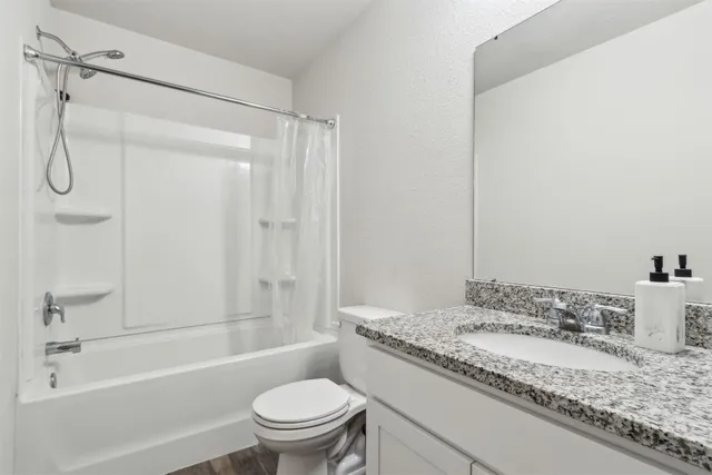 a bathroom with a granite countertop sink toilet and shower