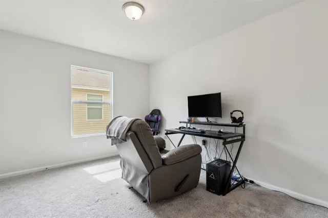 a living room with furniture a flat screen tv and a window