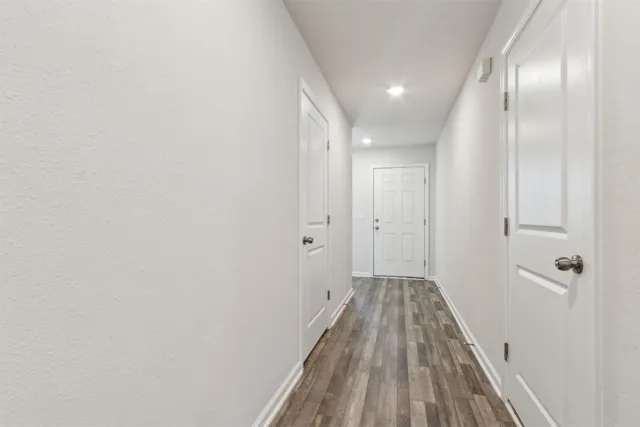 a view of a hallway with wooden floor