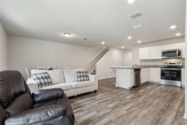 a living room with furniture and kitchen view