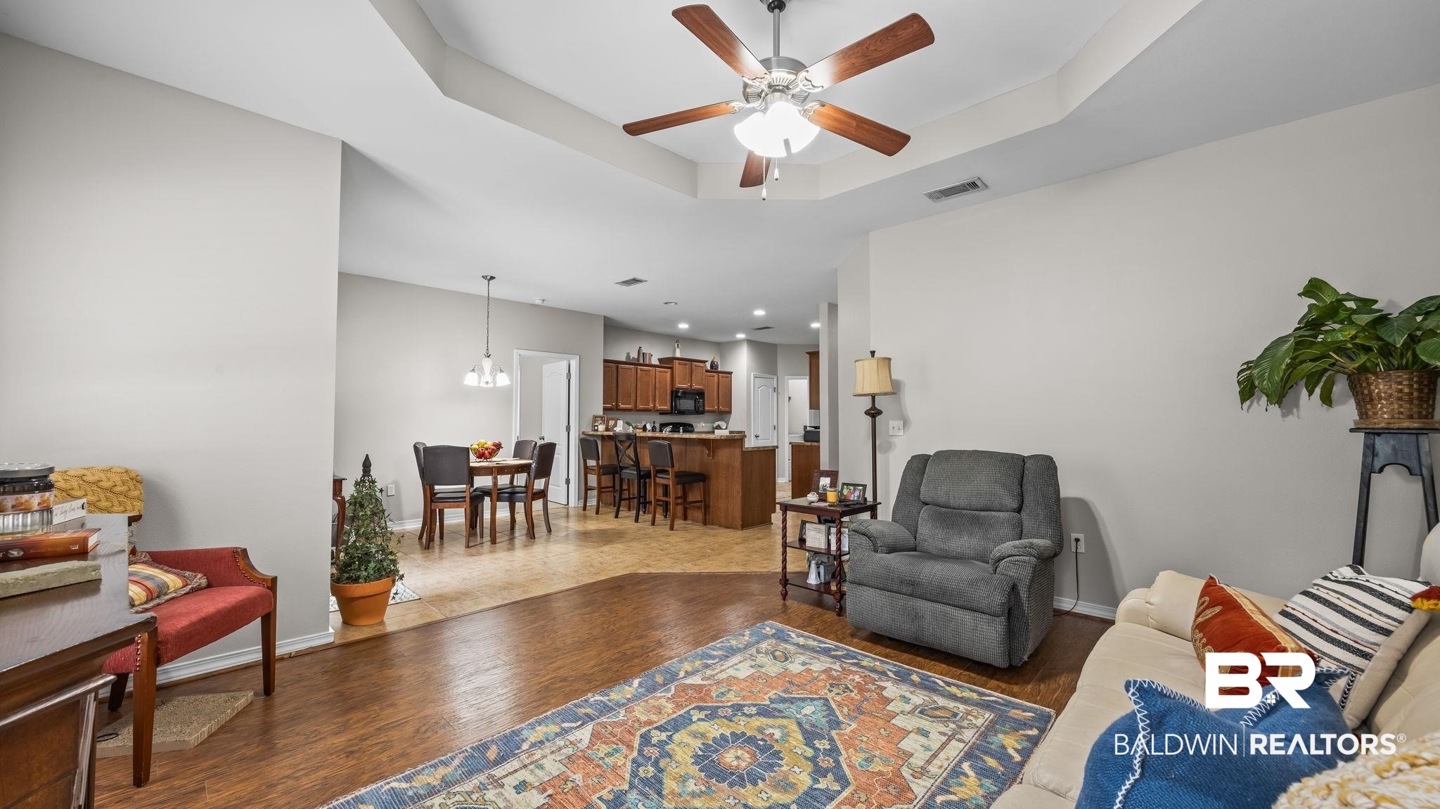 1090 Melbourne Court Foley, AL 36535 - Photo 38 of 38 Living area featuring a raised ceiling, a ceiling fan, and dark wood-style floors