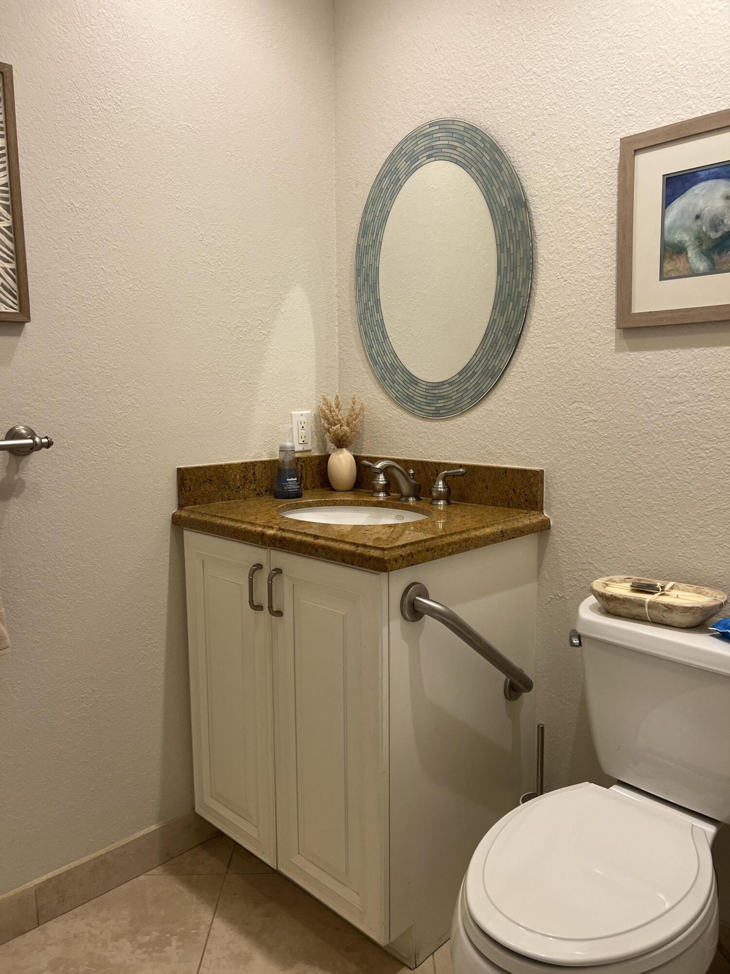 330 Southeast 20th Avenue, Unit 315 Deerfield Beach, FL 33441 - Photo 33 of 33 a bathroom with a toilet a sink and mirror