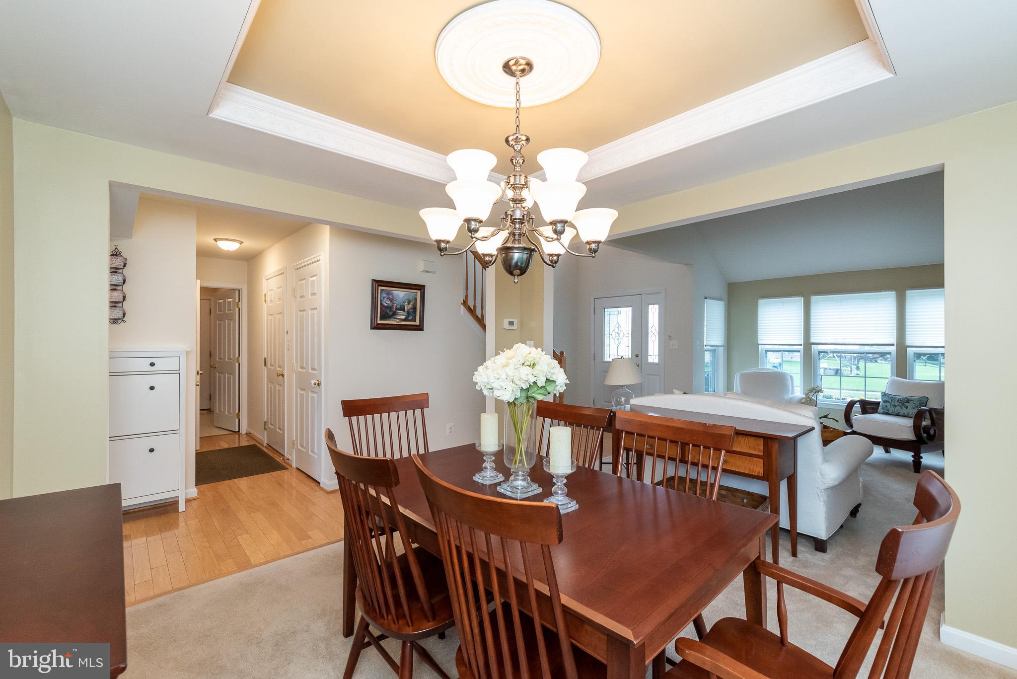 709 Walnut Grove Road Baltimore, MD 21221 - Photo 11 of 52 a view of a dining room with furniture a chandelier and wooden floor