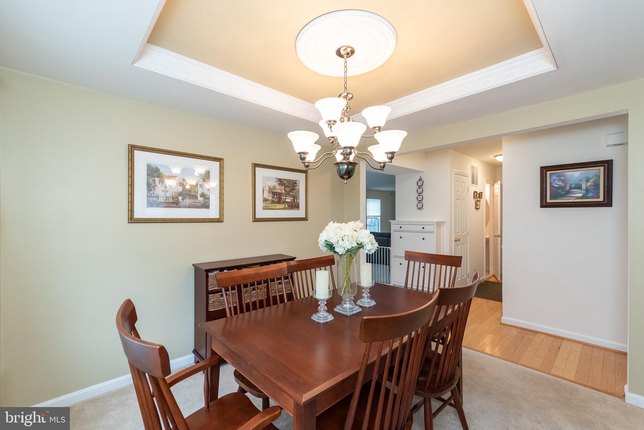 709 Walnut Grove Road Baltimore, MD 21221 - Photo 12 of 52 a view of a dining room with furniture a chandelier and wooden floor