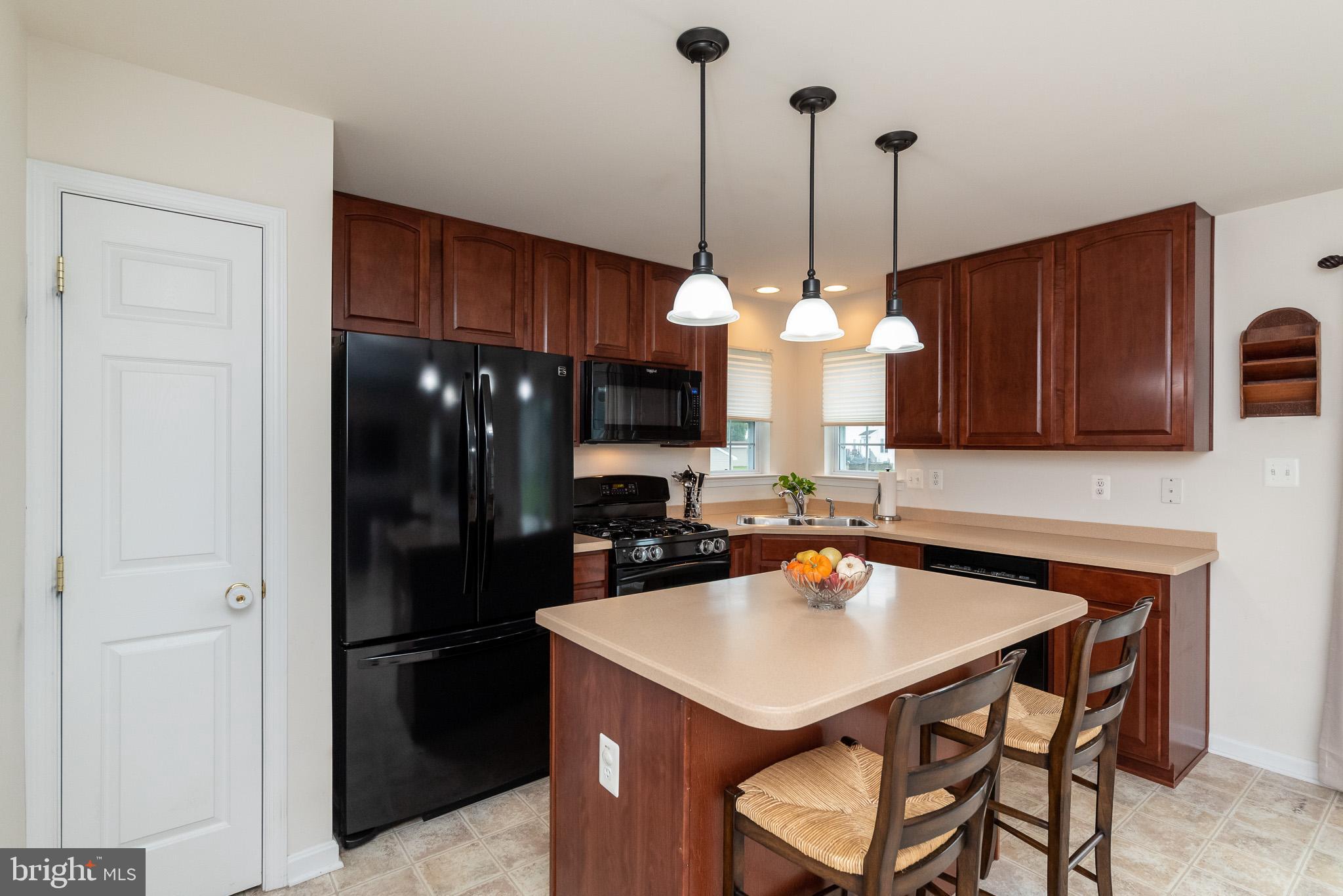 709 Walnut Grove Road Baltimore, MD 21221 - Photo 17 of 52 a kitchen with a dining table chairs a sink and a refrigerator