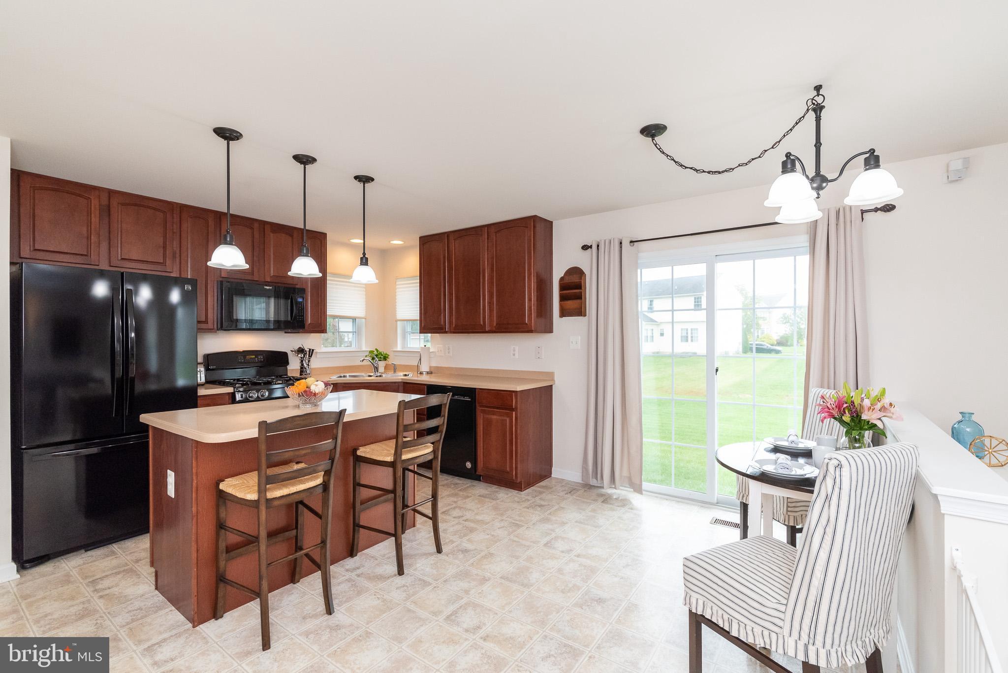 709 Walnut Grove Road Baltimore, MD 21221 - Photo 26 of 52 a kitchen with stainless steel appliances granite countertop a stove a refrigerator a oven a sink with a dining table and chairs