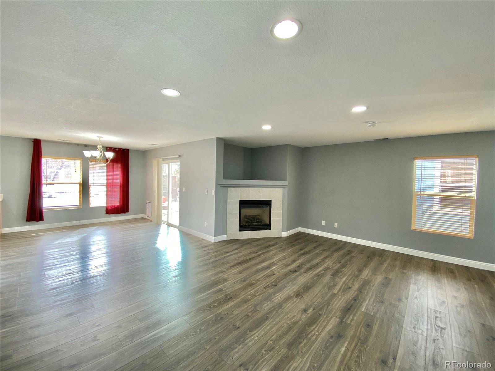 5731 Raleigh Circle Castle Rock, CO 80104 - Photo 4 of 16 an empty room with wooden floor and fireplace