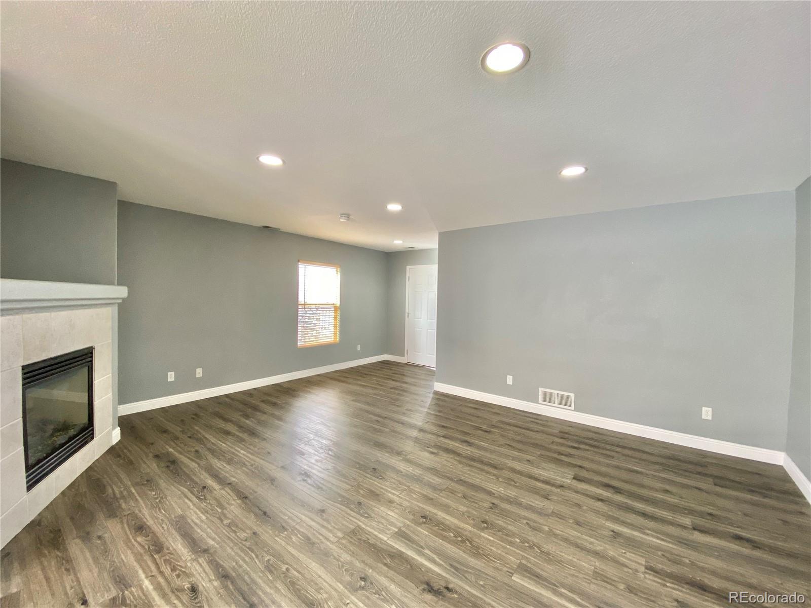 5731 Raleigh Circle Castle Rock, CO 80104 - Photo 5 of 16 a view of empty room with wooden floor and fireplace