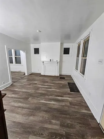 a view of a livingroom with wooden floor and stairs