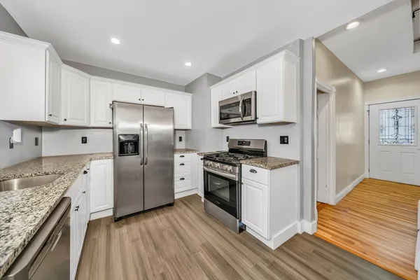 a kitchen with stainless steel appliances granite countertop a stove a refrigerator and a sink