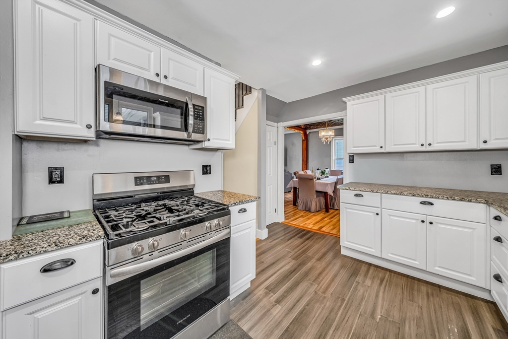8 Ford Street Haverhill, MA 01832 - Photo 16 of 41 a kitchen with stainless steel appliances granite countertop white cabinets and wooden floor