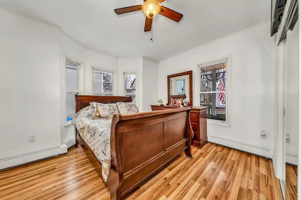 a bed room with a bed and a chandelier fan