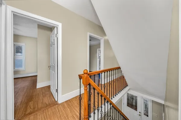 a view of a hallway with wooden floor and entryway