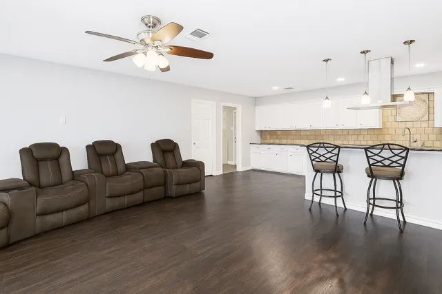 a living room with furniture and a wooden floor