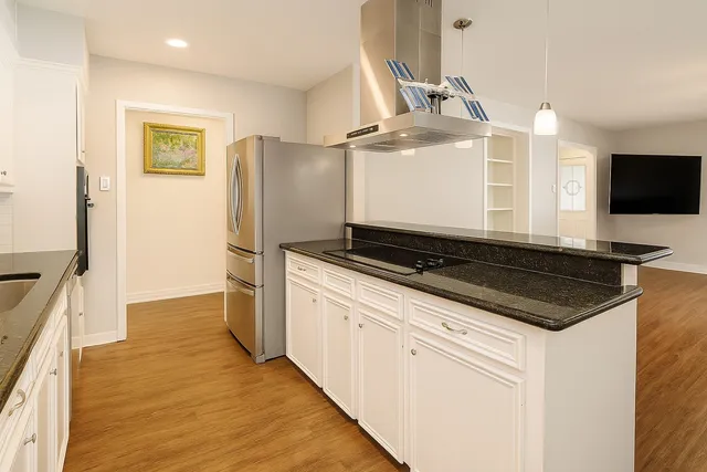 a kitchen with stainless steel appliances granite countertop a refrigerator and a stove top oven