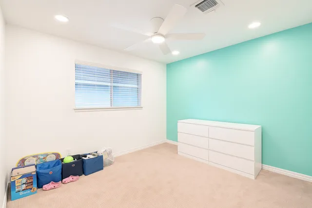 a bedroom with a bed and a ceiling fan