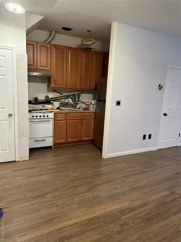 a kitchen with granite countertop a refrigerator and a stove top oven