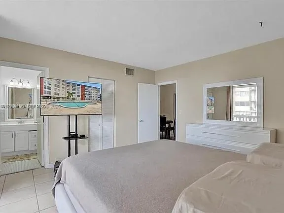 a large bedroom with a bed and table chair