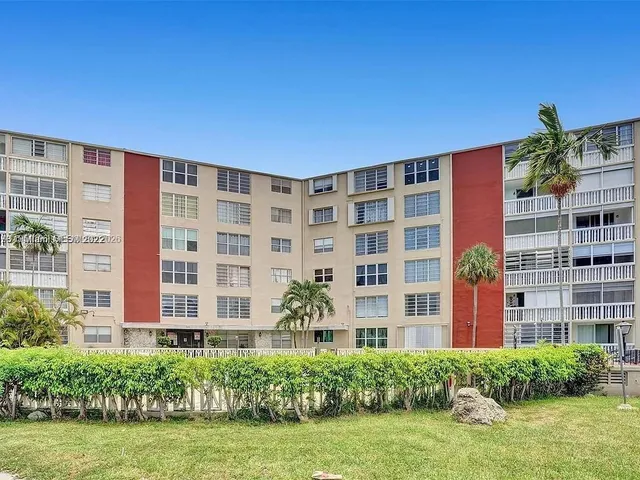 a front view of a building with an garden and plants