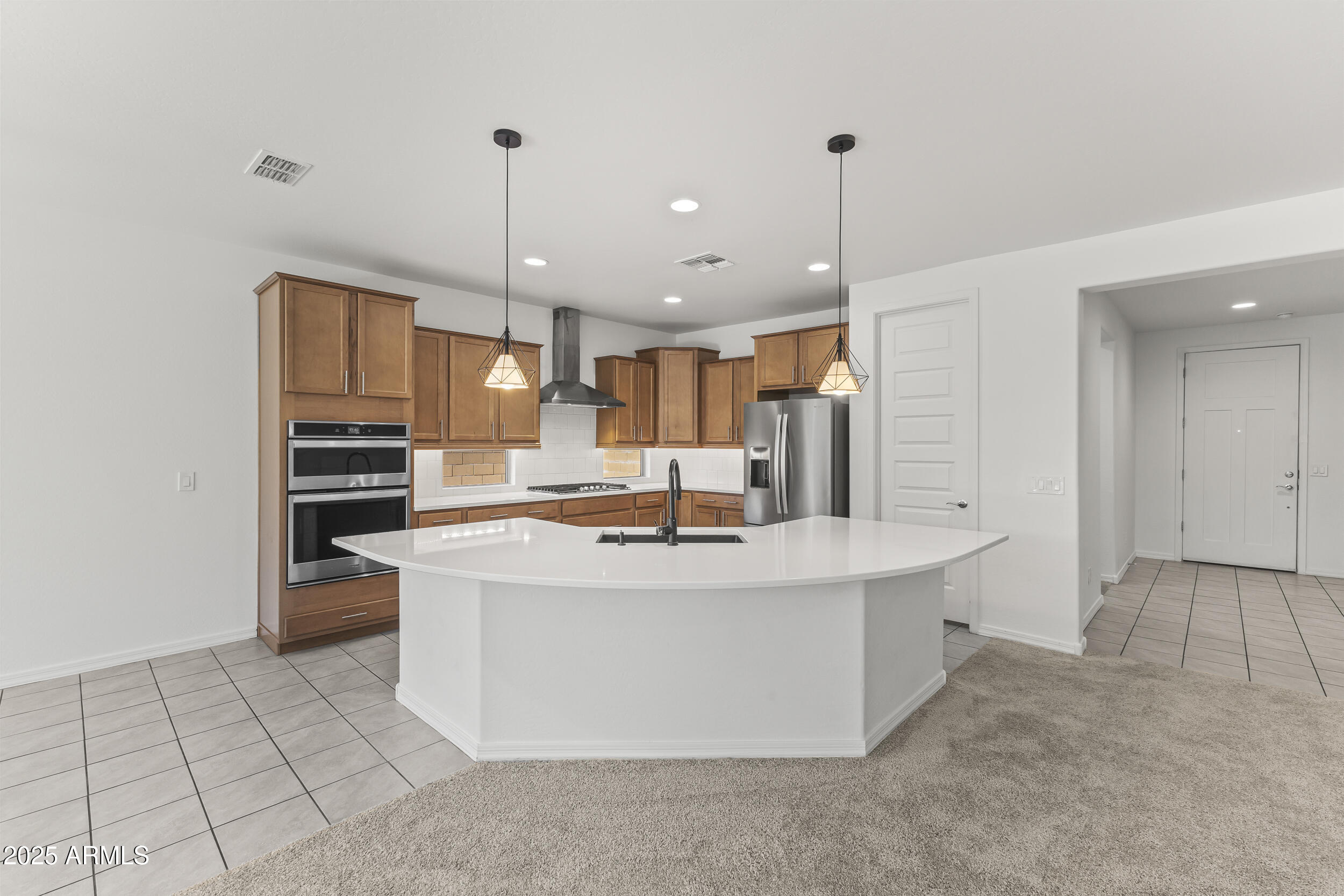 25915 West Quail Avenue Buckeye, AZ 85396 - Photo 16 of 73 a view of kitchen with kitchen island stainless steel appliances a stove a sink and a refrigerator
