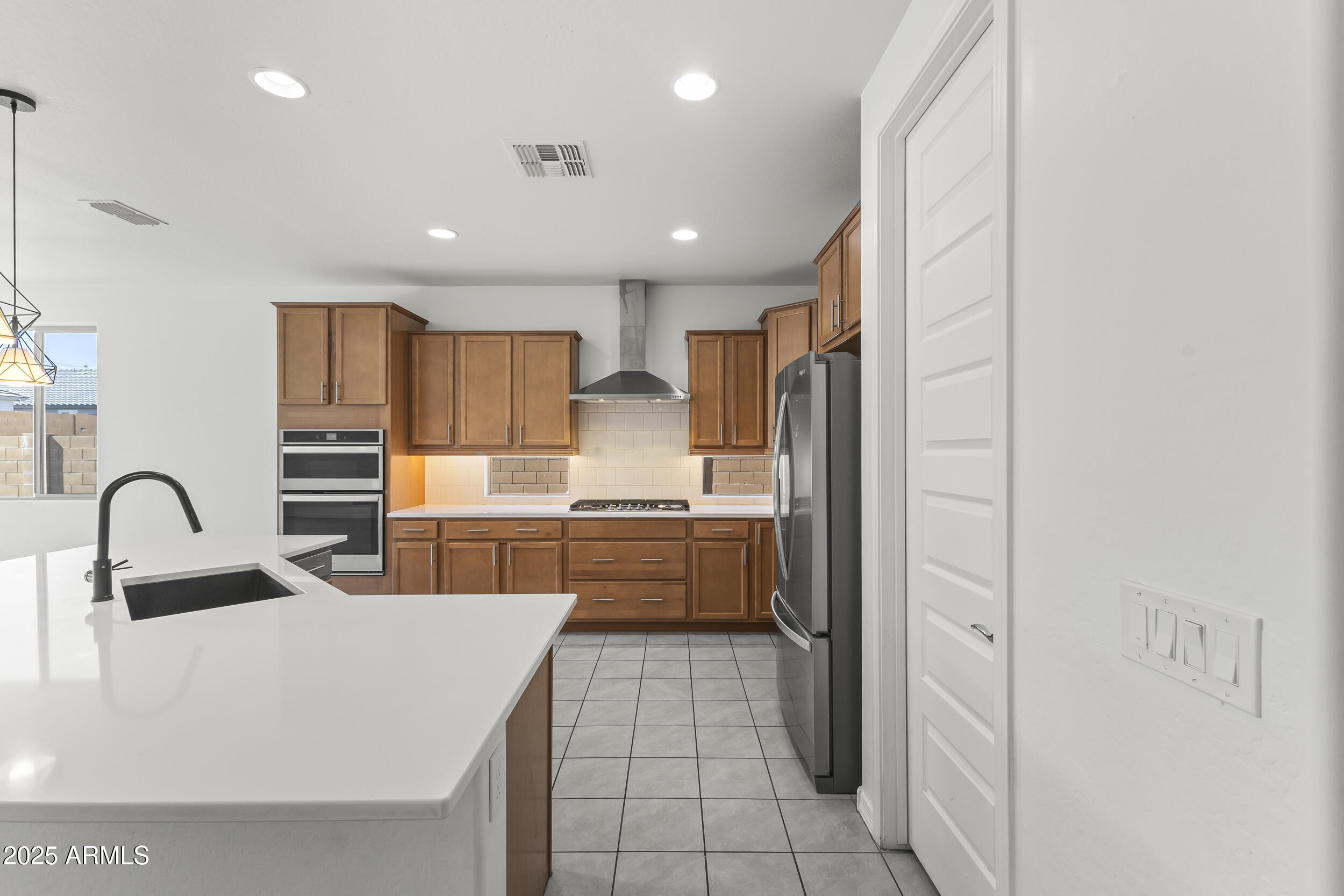 25915 West Quail Avenue Buckeye, AZ 85396 - Photo 19 of 73 a kitchen with kitchen island granite countertop a sink stainless steel appliances and cabinets