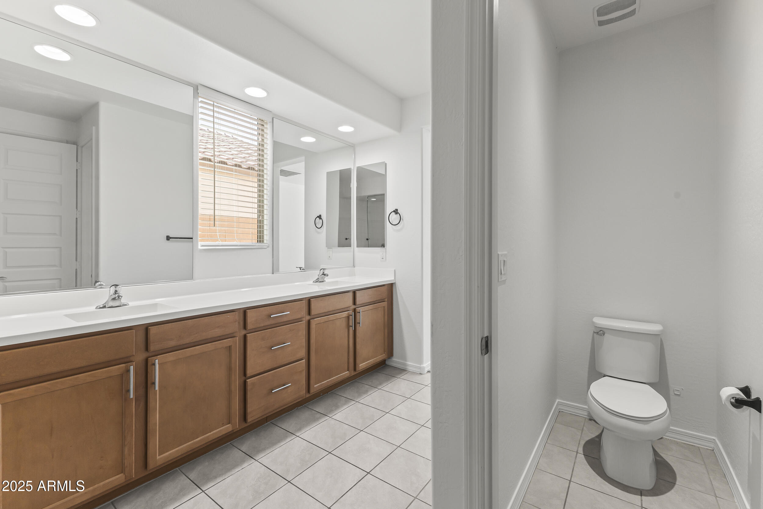 25915 West Quail Avenue Buckeye, AZ 85396 - Photo 35 of 73 a spacious bathroom with a toilet sink and mirror