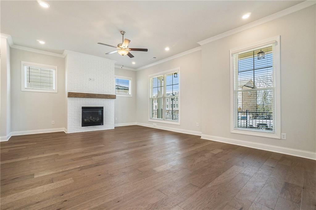 106 Basil Street Cumming, GA 30040 - Photo 6 of 25 an empty room with windows fireplace and a kitchen view