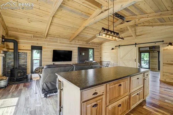 a kitchen with stainless steel appliances granite countertop a refrigerator a sink a stove and a wooden floors