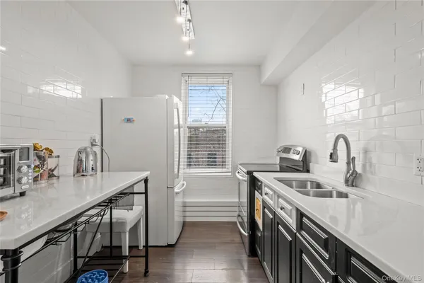 a kitchen that has a sink a stove and chairs