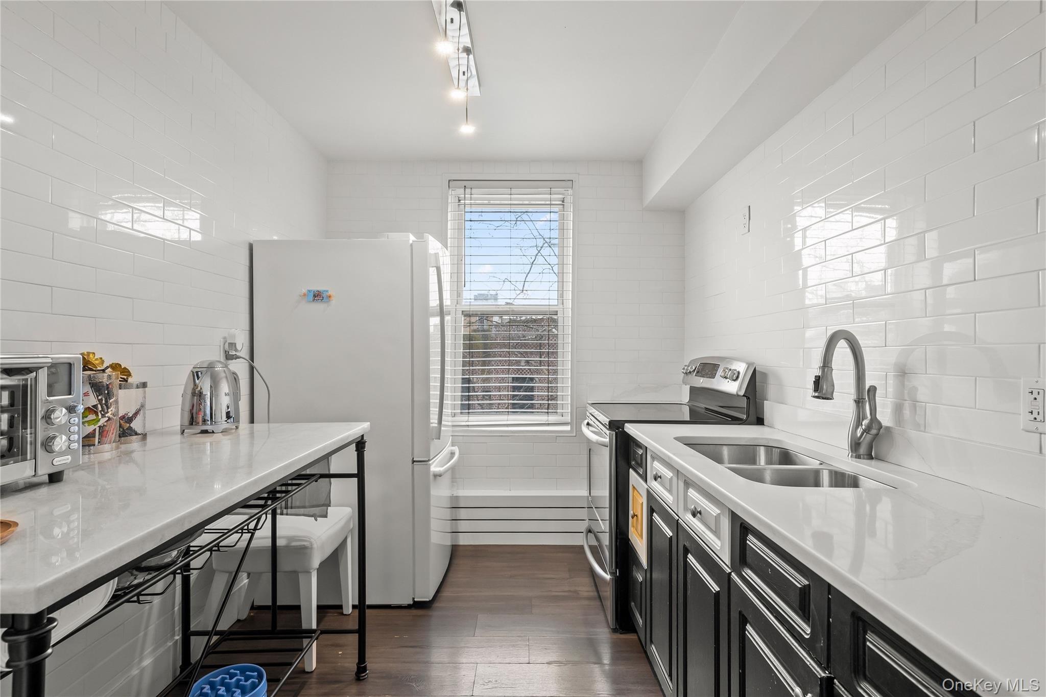a kitchen that has a sink a stove and chairs