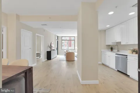 a kitchen with a refrigerator and white cabinets
