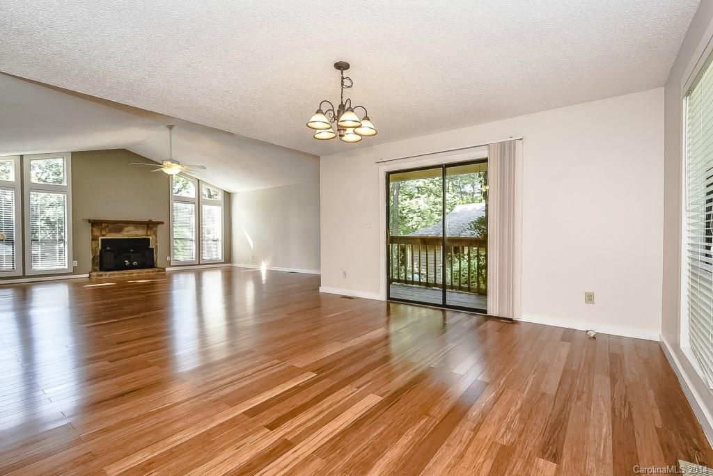 5064 Suwarrow Circle Tega Cay, SC 29708 - Photo 11 of 23 an empty room with wooden floor fireplace and windows