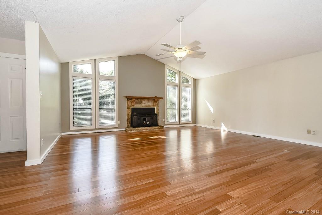 5064 Suwarrow Circle Tega Cay, SC 29708 - Photo 3 of 23 an empty room with wooden floor fireplace and windows