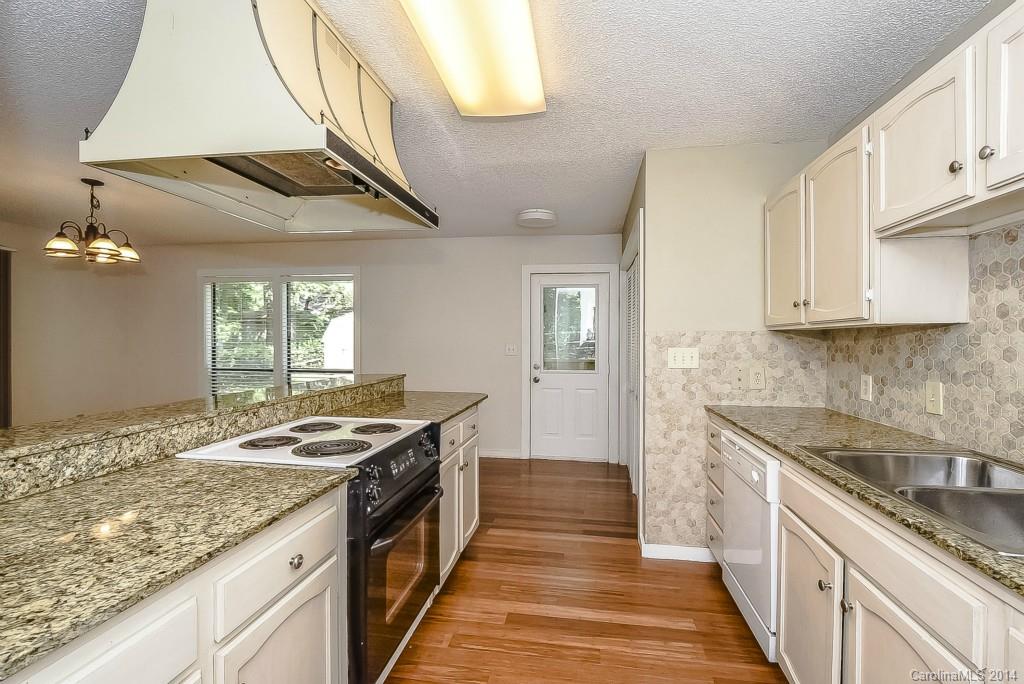 5064 Suwarrow Circle Tega Cay, SC 29708 - Photo 10 of 23 a kitchen with granite countertop stainless steel appliances a sink stove and cabinets