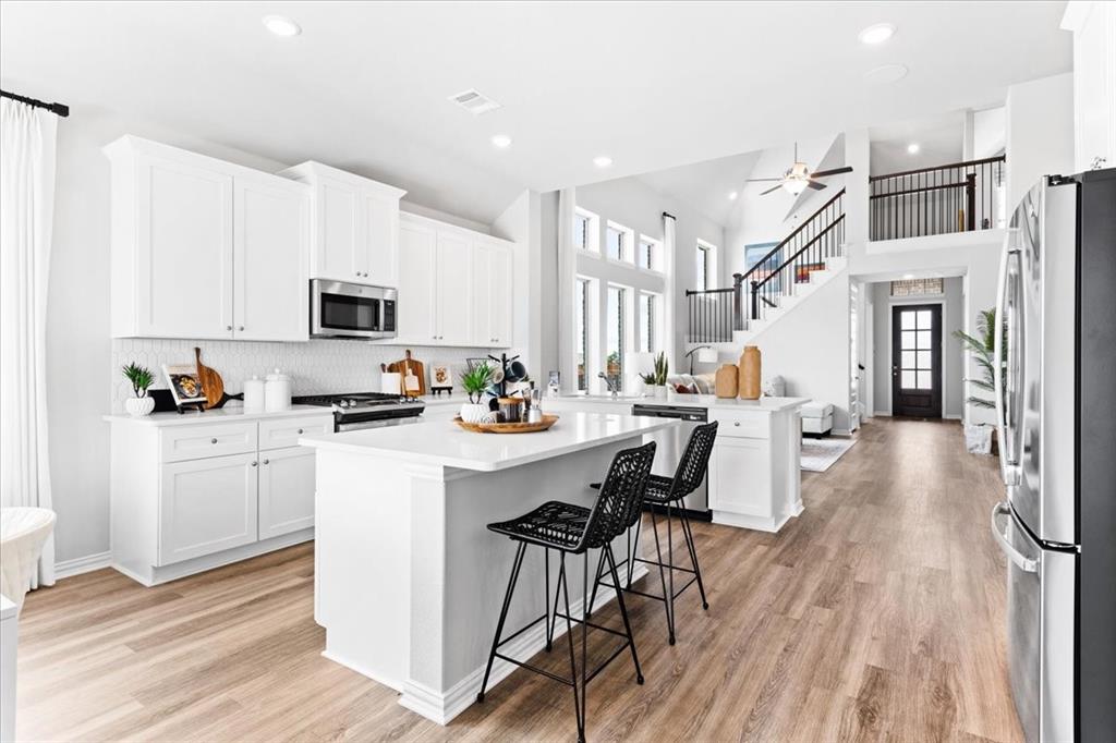 2339 Butler Avenue Fate, TX 75087 - Photo 8 of 35 a kitchen with stainless steel appliances a white table chairs and a refrigerator