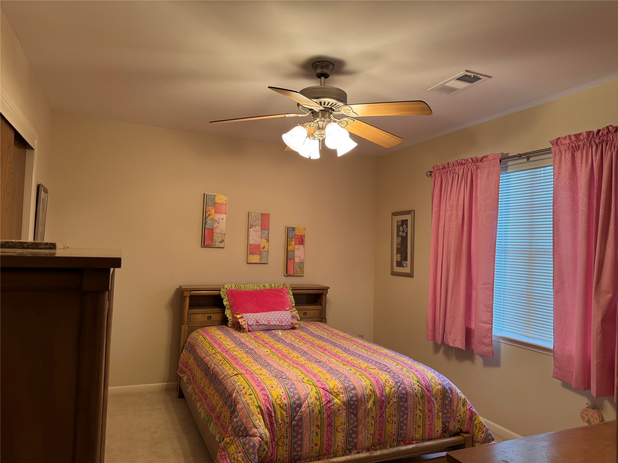 203 East Thornton Road Houston, TX 77022 - Photo 14 of 18 Cozy second-floor bedroom features soft beige walls and a ceiling fan