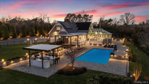 a view of a house with backyard water fountain and sitting area