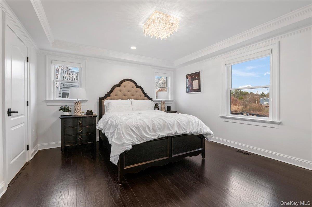 19 West Tiana Road Hampton Bays, NY 11946 - Photo 38 of 50 a bedroom with a bed and a chandelier