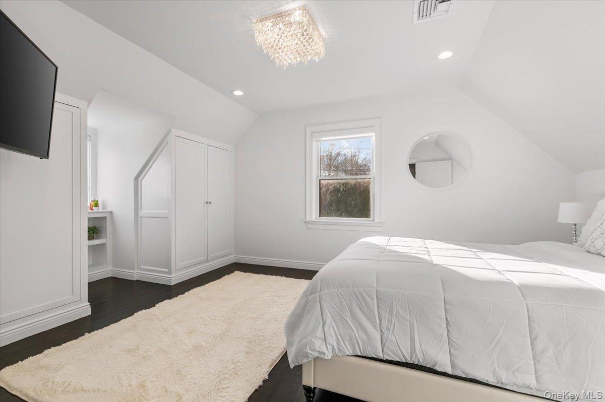 19 West Tiana Road Hampton Bays, NY 11946 - Photo 40 of 50 a bedroom with a bed and a flat screen tv