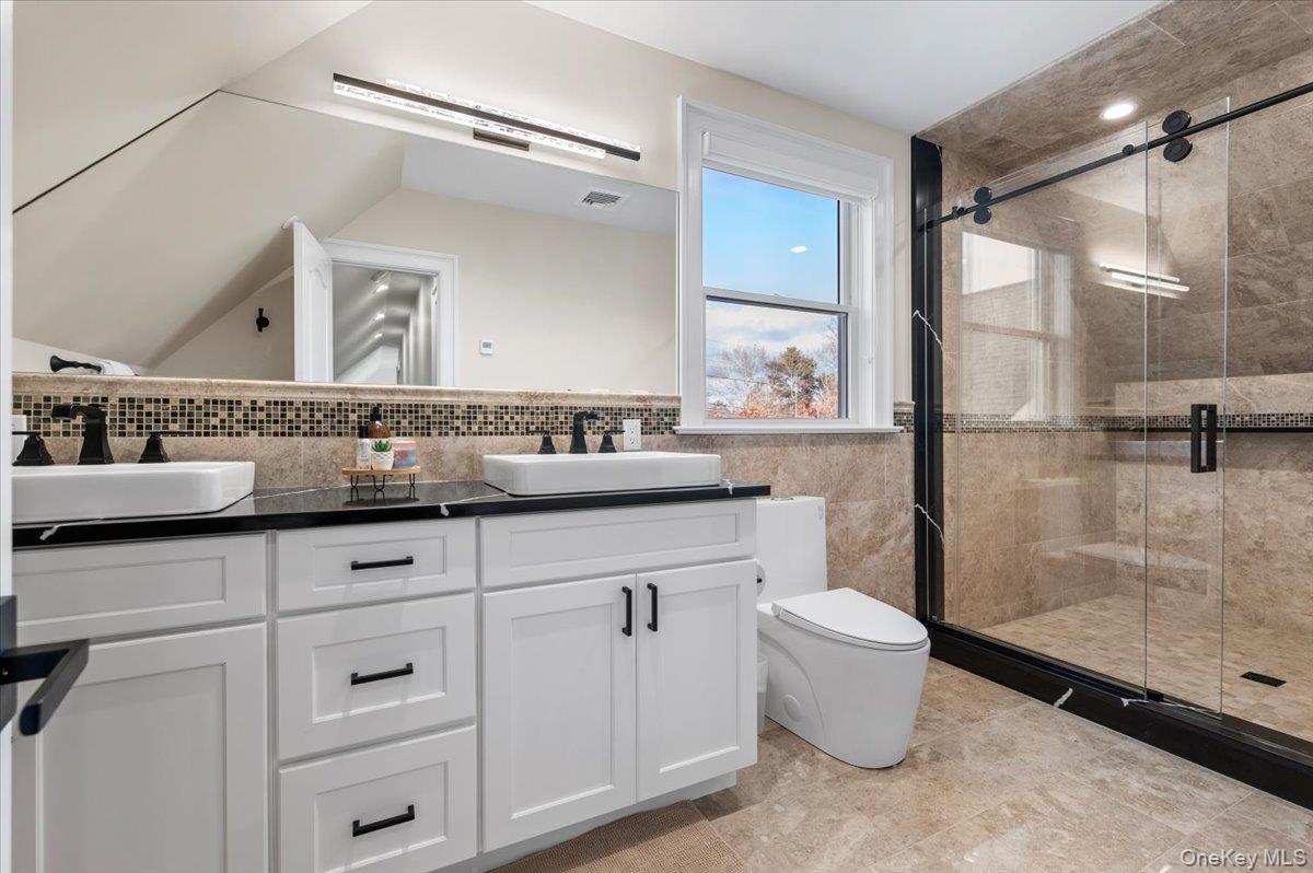 19 West Tiana Road Hampton Bays, NY 11946 - Photo 41 of 50 a bathroom with a sink mirror vanity and toilet