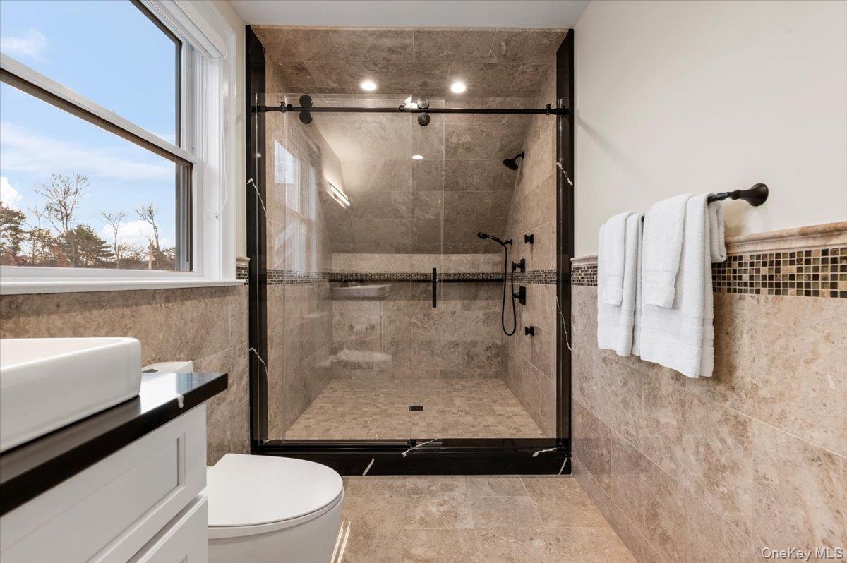 19 West Tiana Road Hampton Bays, NY 11946 - Photo 42 of 50 a bathroom with a granite countertop bathtub shower sink vanity and toilet