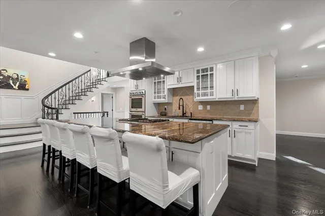 a kitchen with stainless steel appliances kitchen island granite countertop a sink and cabinets