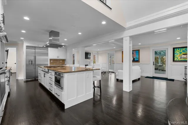 a large white kitchen with a large counter top appliances and cabinets