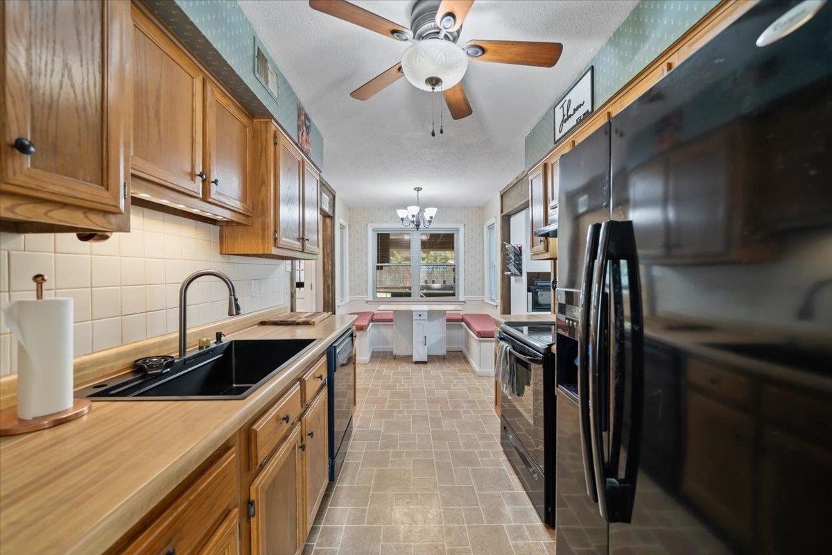 6315 Bardstown Road Bartlett, TN 38134 - Photo 12 of 31 Kitchen with black appliances, wallpapered walls, hanging lights, a ceiling fan, and light countertops