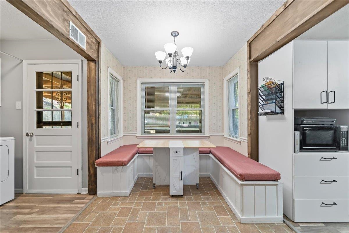6315 Bardstown Road Bartlett, TN 38134 - Photo 15 of 31 Unfurnished dining area featuring breakfast area, a textured ceiling, washer / dryer, a chandelier, and a wainscoted wall