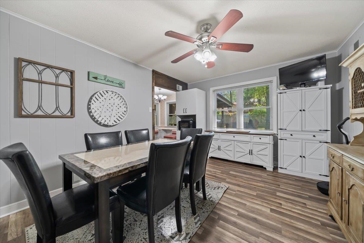 6315 Bardstown Road Bartlett, TN 38134 - Photo 17 of 31 Dining room featuring crown molding, a ceiling fan, dark wood finished floors, and a chandelier