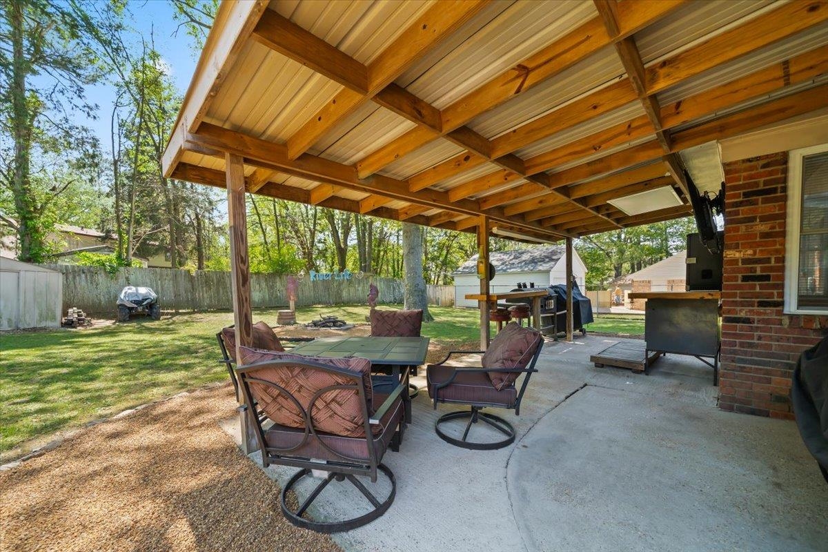 6315 Bardstown Road Bartlett, TN 38134 - Photo 23 of 31 Fenced backyard featuring a storage unit, a patio, and outdoor dining area