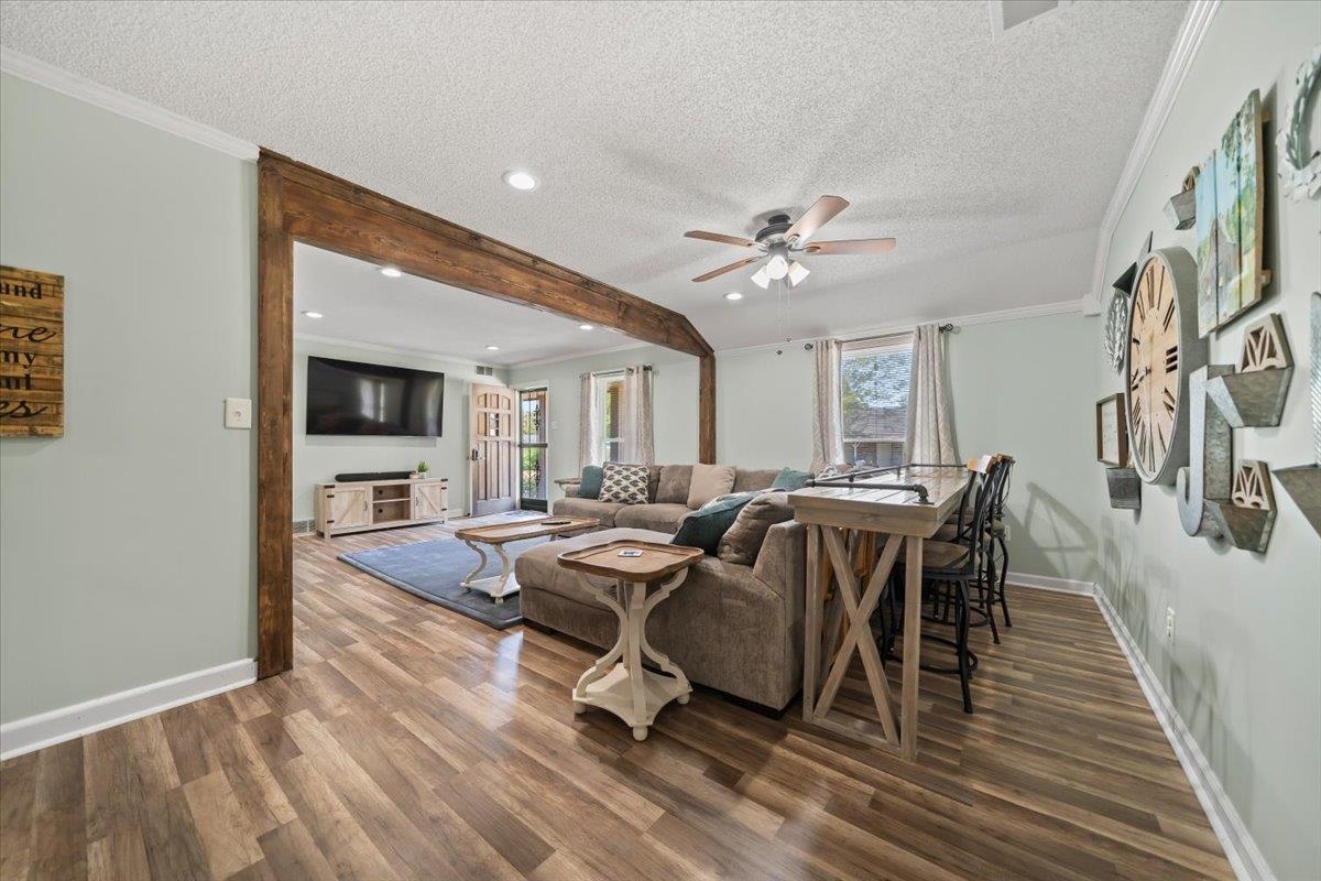 6315 Bardstown Road Bartlett, TN 38134 - Photo 9 of 31 Living area featuring ornamental molding, ceiling fan, a textured ceiling, wood finished floors, and healthy amount of natural light