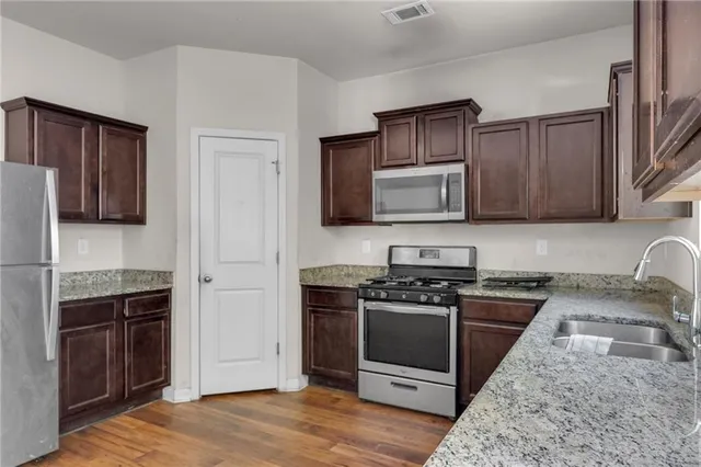a kitchen with wooden cabinets and stainless steel appliances